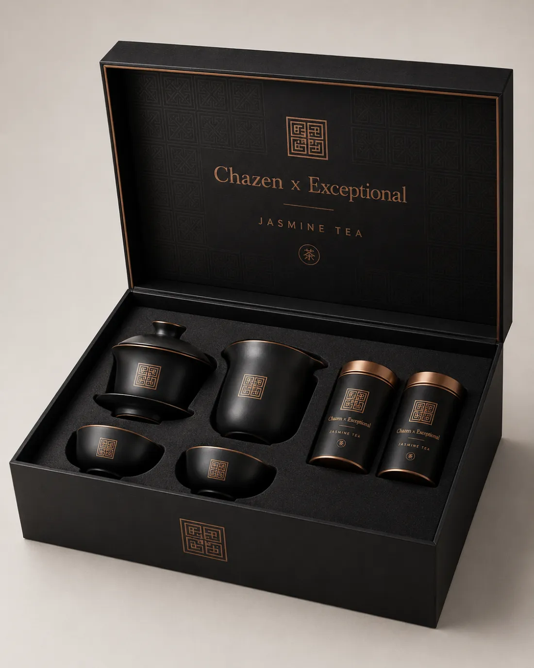 An open black gift box; the lid reads Chazen x Exceptional, Jasmine Tea in bronze. Inside sit a lidded gaiwan, a pitcher, two cups and two bronze-capped tins.