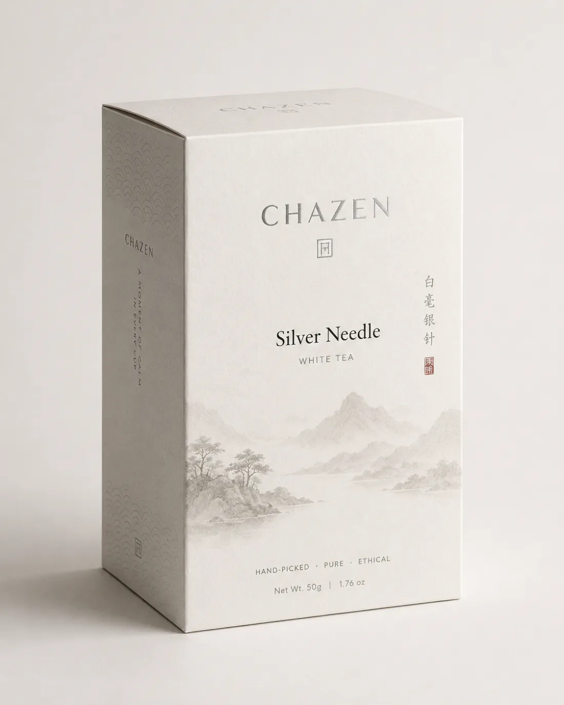 Pale ivory Silver Needle carton with silver foil type and a soft grey ink landscape