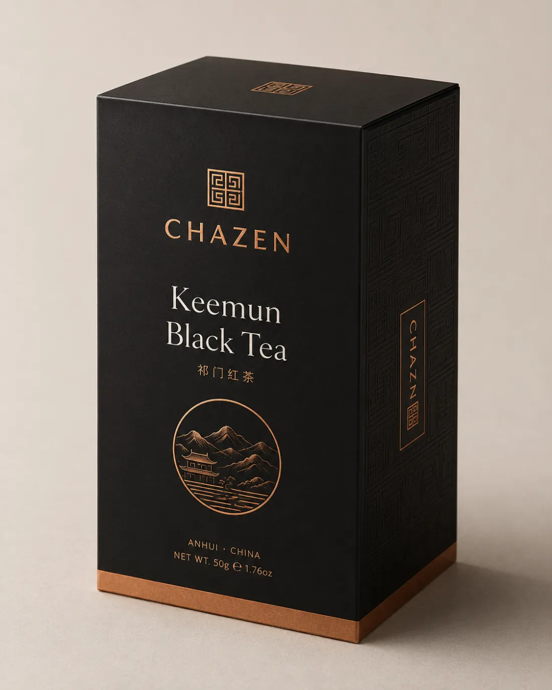 A black Chazen carton with copper foil type reading Keemun Black Tea, above an engraved circle of mountains and a pavilion.