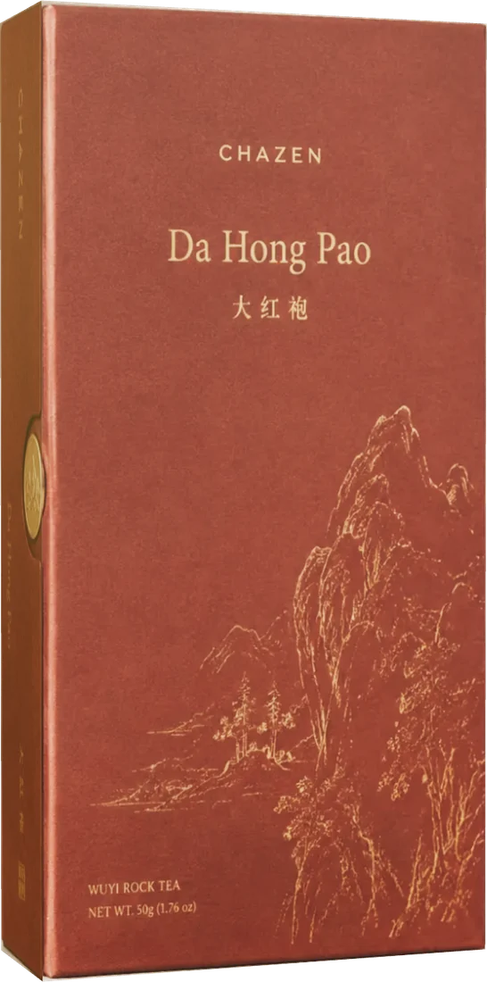 A Da Hong Pao tea box: a red book-form carton with the Wuyi cliffs printed in gold across the face and a gold seal set into the spine.